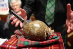Recital of Robert Burns’ Address to a Haggis at a traditional Burns Night supper with haggis, neeps, tatties, and whisky on a tartan table.