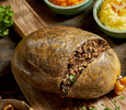 Macsween haggis served with creamy tatties and buttery neeps on a tartan tablecloth.