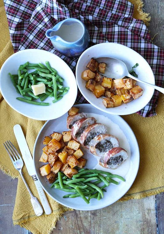Chicken Balmoral with Macsween haggis wrapped in bacon and topped with creamy whisky sauce, served with mashed potatoes and vegetables.