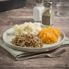 Traditional Scottish haggis served with neeps, tatties, and whisky sauce on a Burns Night table