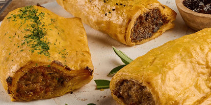 Traditional Scottish Scotch pies and sausage rolls on wooden board