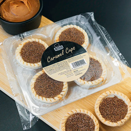 Packaged caramel cupcakes on a wooden board with a dark background