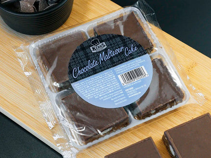 Packaged chocolate malted cake on a wooden board with loose pieces beside it.
