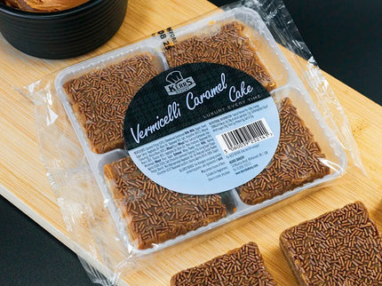 Packaged cake with a label on a wooden board next to slices of cake.