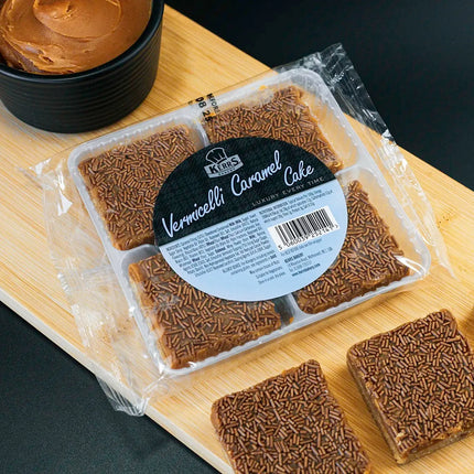 Packaged cake with a label on a wooden board next to slices of cake.