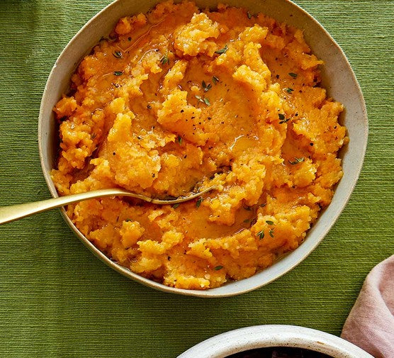 Traditional Scottish swede neeps mashed with butter served alongside haggis and tatties